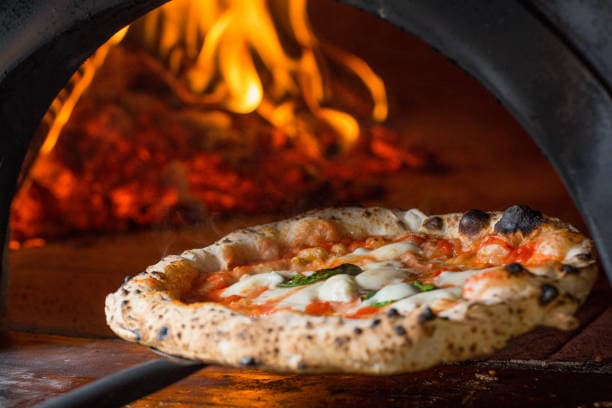 Freshly baked artisan pizza at Tomatoes Pizzeria in Lake Worth